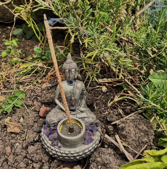 Bamboo incense stick burning inside a buddha incense stick holder