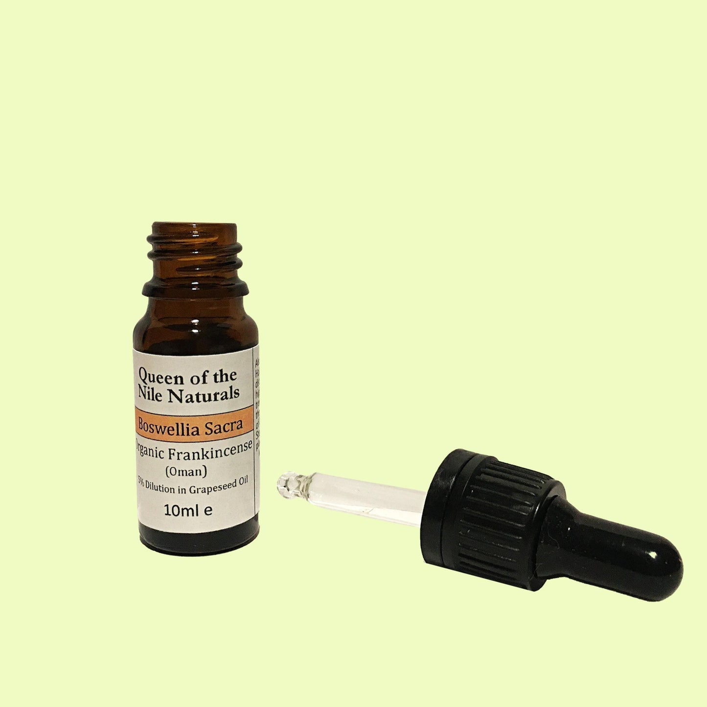 Frankincense essential oil inside a Brown glass dropper bottle with a glass pipet.